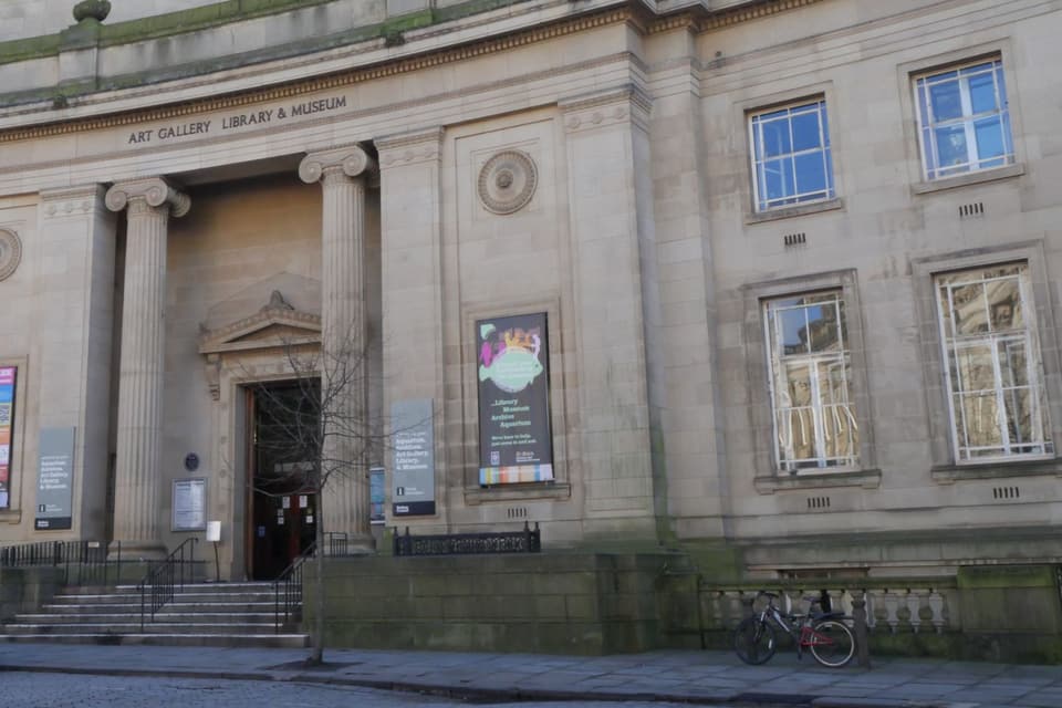 The columned entrance of Bolton's Art Gallery, Library and Museum building, with its name carved above the doorway